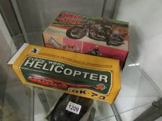 A boxed battery operated police speed cycle and a boxed clockwork helicopter