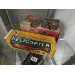 A boxed battery operated police speed cycle and a boxed clockwork helicopter