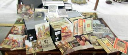 Three boxes containing a large quantity of old postcards, many in protective sleeves,