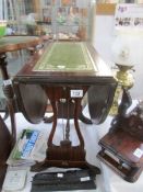 A small drop leaf table with leather top