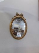 A small oval gilt framed mirror