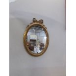 A small oval gilt framed mirror