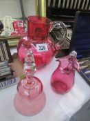 2 cranberry glass jugs and a cranberry glass bell