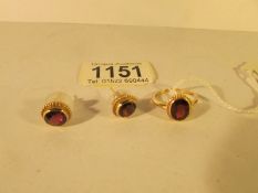 A 9ct gold ring set garnet and a pair of matching earrings
