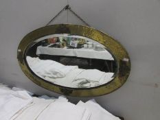 An oval brass framed mirror
