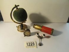 An Edwardian novelty globe pin cushioh/tape measure, a miniature alarm clock pencil sharpener,