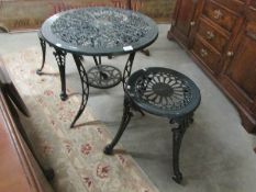 A metal garden table and 2 stools.