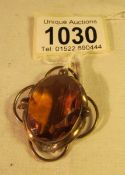 A Victorian brooch set with amber coloured stone and with safety chain