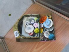 A tin of collector's pin badges