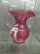 A cranberry glass Mary Gregory style jug