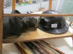 A second world ware black brodie helmet with white 'A' (possibly ambulance) and a gas mask