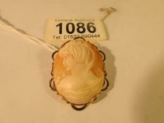 A cameo brooch with female profile in 9ct gold with attached safety chain