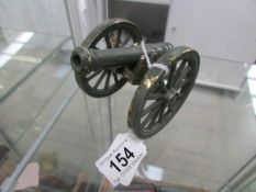 A green painted over brass model cannon,
