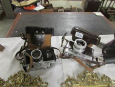 A cased USSR Zorki camera and a cased Minolta camera.