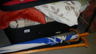 A suitcase of cushions and umbrella's.