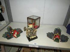 An oriental seated figure, a pair of peacock wall masks and a cased oriental crown.