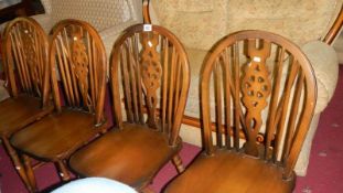 A set of 4 wheel back chairs,