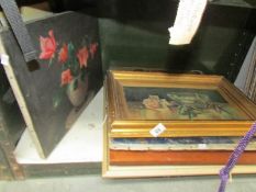 A shelf of paintings and prints.