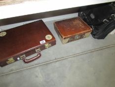 A small vintage suitcase, a briefcase and one other case.