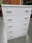 A white 5 drawer chest.