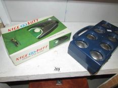 A set of boules and a golf putting trainer,.