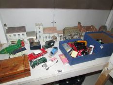 A quantity of unboxed Lledo, Matchbox die cast models and cardboard buildings.