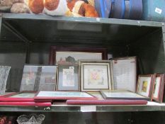 A shelf of framed and glazed prints.