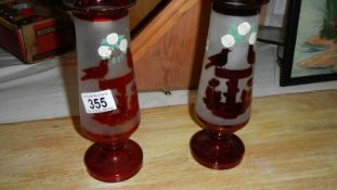 A pair of ruby glass engraved vases.