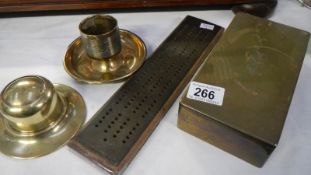 A brass cribbage board, brass inkwell, brass matchstriker and brass box.