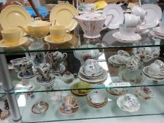 3 shelves of assorted tea ware.