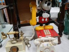 A Mickey Mouse phone and 2 other phone related items.