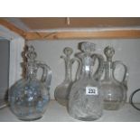5 glass wine jugs including cut glass, etched glass and hand painted examples.