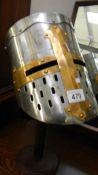 A replica crusader/Knight Templar helmet on stand.