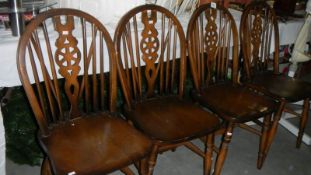 A set of 4 wheel back chairs.