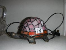 A Tiffany style table lamp in the shape of a tortoise.