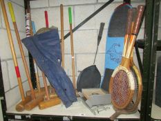 A shelf of tennis rackets, croquet items etc.