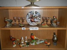 A collection of pheasant ornaments and figurines, 2 shelves.