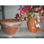 A large terracotta pot and a terracotta vase with silk flowers,.