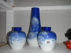 A pair of blue and white vases with snow scenes and a taller example (tall vase a/f)