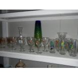 A shelf of glass ware including decorated glasses.