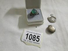 A silver ring set green stone, a silver St. Christopher and a Silver locket.