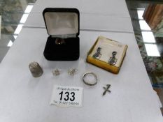 2 pairs of silver earrings, 2 silver rings, a silver thimble and a small silver cross.