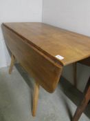 An Ercol drop leaf dining table.