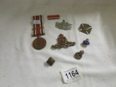 A WW1 medal and ribbon, an 1897 medal, military cap badges etc.