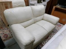 A cream leather 2 seat sofa.