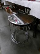 A set of 2 circular chrome tables with mirrored tops.