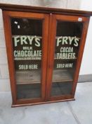 An oak glazed cabinet with Fry's Chocolate advertising on doors.