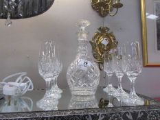 A cut glass decanter and 6 cut glass wine glasses.