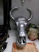 A silver coloured wall hanging bull head.