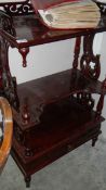 A mahogany shelf unit with drawer.